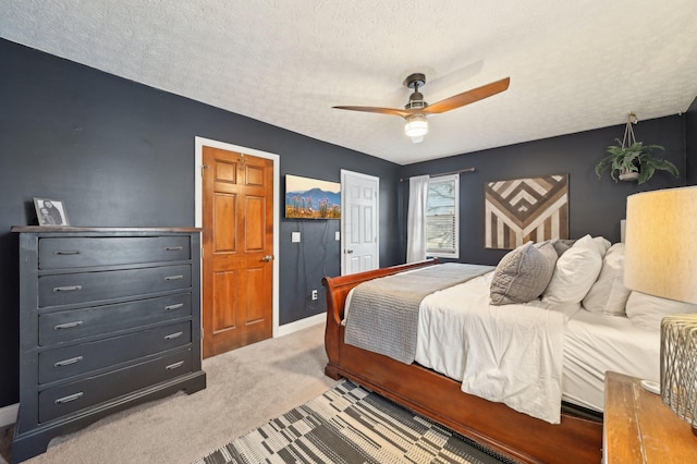 bedroom featuring ceiling fan, light carpet, and a textured ceiling