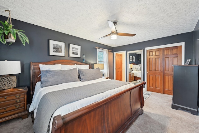 carpeted bedroom with ceiling fan and a textured ceiling