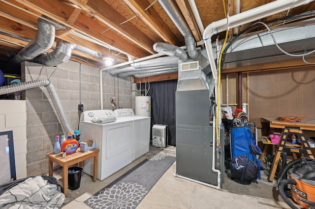 basement with electric water heater, washer and dryer, and heating unit