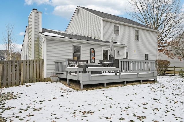 snow covered rear of property featuring a deck