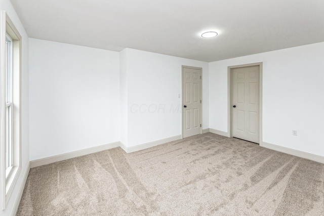 unfurnished room featuring light carpet