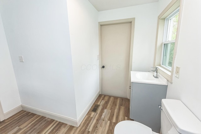 bathroom with vanity, wood-type flooring, and toilet