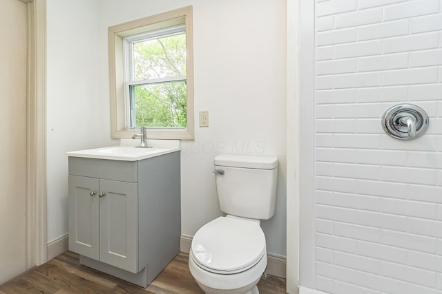 bathroom with hardwood / wood-style flooring, vanity, and toilet