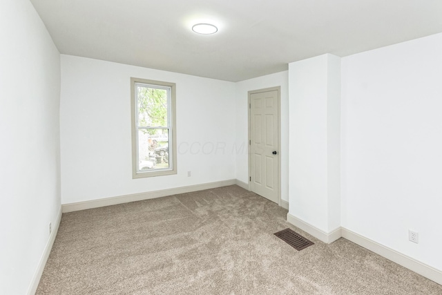 spare room featuring light colored carpet