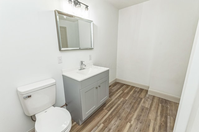 bathroom featuring wood-type flooring, vanity, and toilet