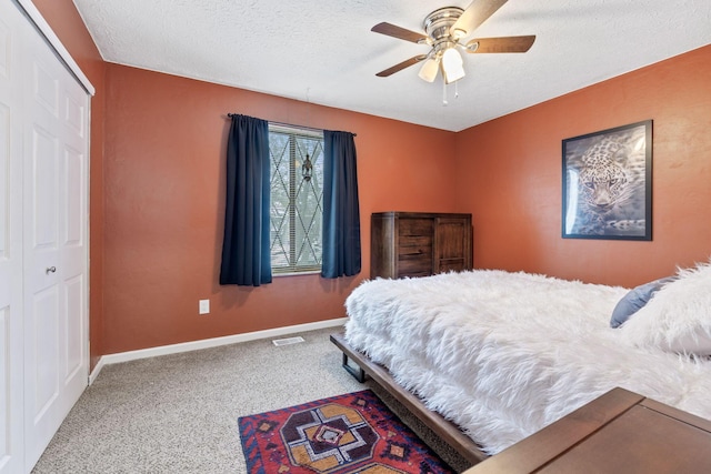 bedroom featuring carpet flooring, a textured ceiling, a closet, and ceiling fan