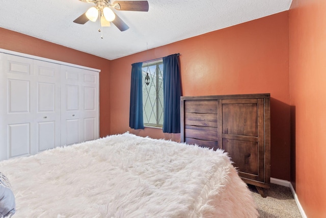 carpeted bedroom featuring ceiling fan, a closet, and a textured ceiling