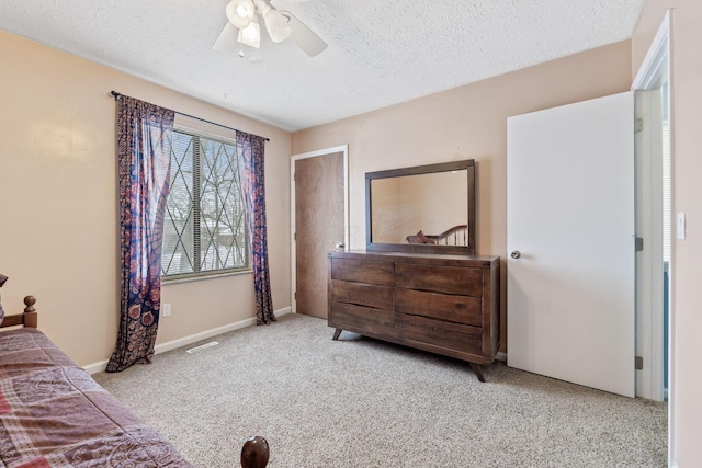 bedroom featuring a textured ceiling, ceiling fan, and light carpet