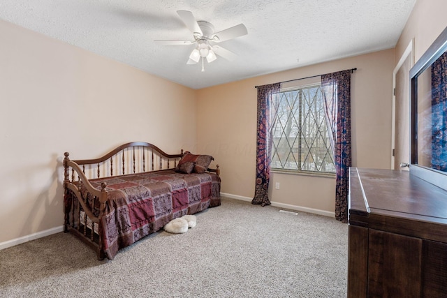 bedroom with a textured ceiling, carpet floors, and ceiling fan