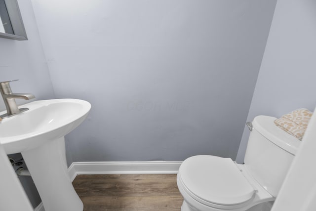 bathroom with sink, toilet, and hardwood / wood-style flooring