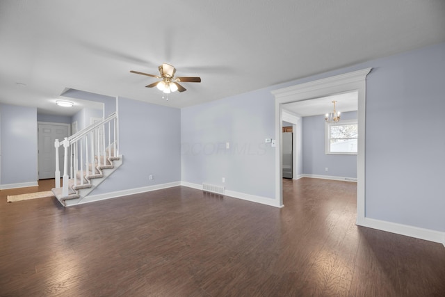 unfurnished living room featuring ceiling fan with notable chandelier and dark wood-type flooring