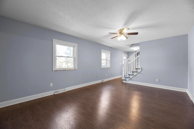 spare room featuring a textured ceiling, ceiling fan, and dark hardwood / wood-style floors