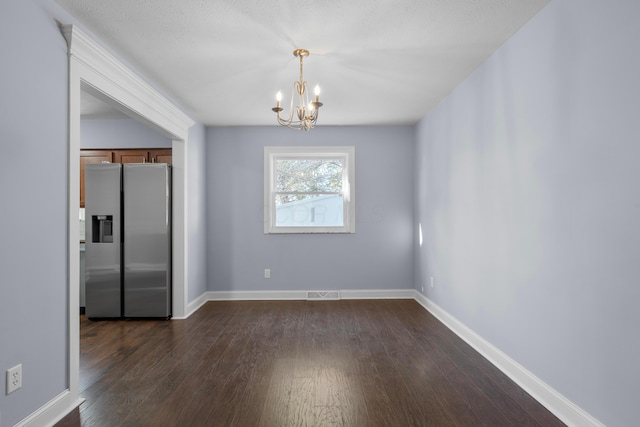 unfurnished dining area with dark hardwood / wood-style flooring and a notable chandelier