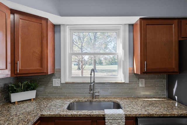 kitchen with light stone countertops, sink, and tasteful backsplash