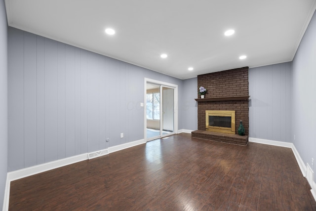 unfurnished living room featuring hardwood / wood-style floors and a brick fireplace