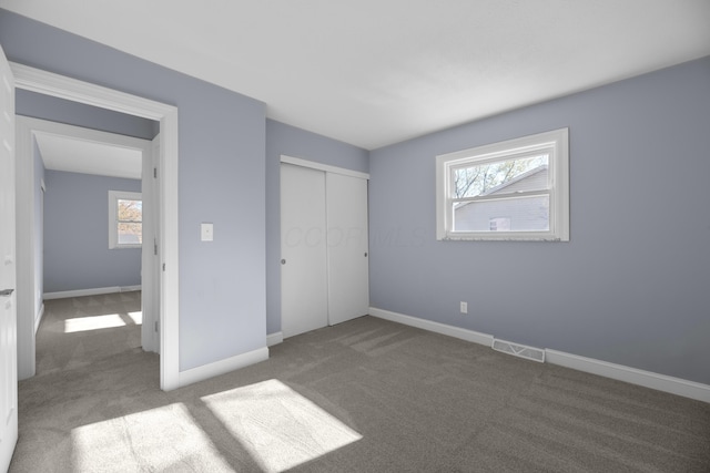 unfurnished bedroom featuring carpet flooring and a closet