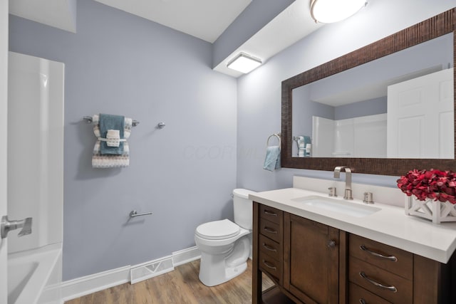 full bathroom with vanity, hardwood / wood-style flooring, toilet, and shower / washtub combination