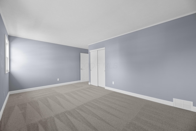 unfurnished room with carpet floors and crown molding