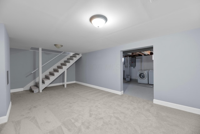 basement featuring washer and clothes dryer, carpet flooring, and electric panel