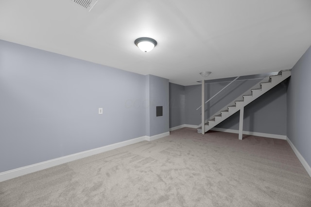 basement featuring light carpet