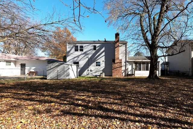 rear view of property with a storage unit