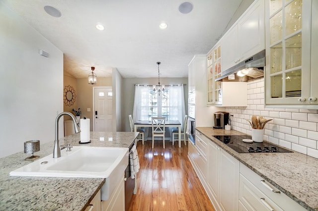 kitchen with pendant lighting, white cabinetry, and exhaust hood