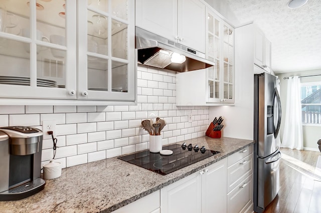 kitchen featuring white cabinets, stainless steel fridge with ice dispenser, black electric cooktop, and light stone countertops