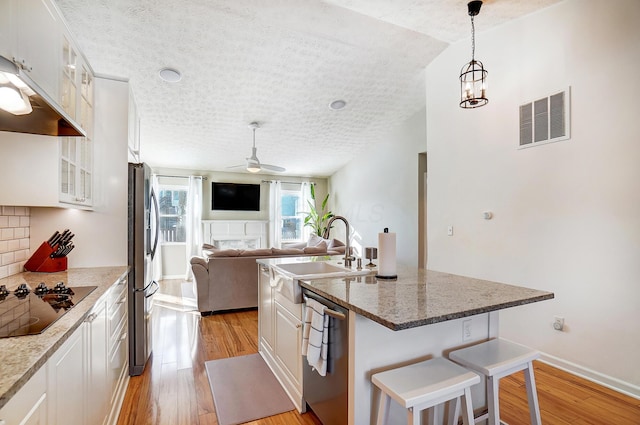 kitchen with white cabinets, a breakfast bar, and stainless steel appliances