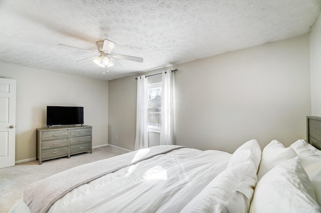 carpeted bedroom with ceiling fan and a textured ceiling