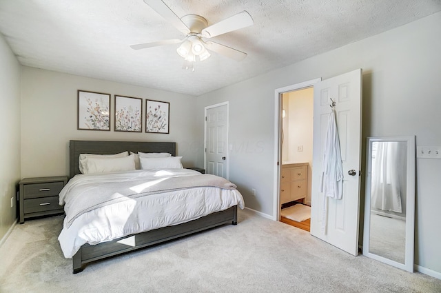 carpeted bedroom featuring ensuite bathroom, ceiling fan, and a textured ceiling