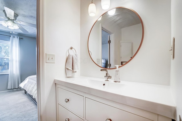 bathroom featuring ceiling fan, vanity, and a textured ceiling