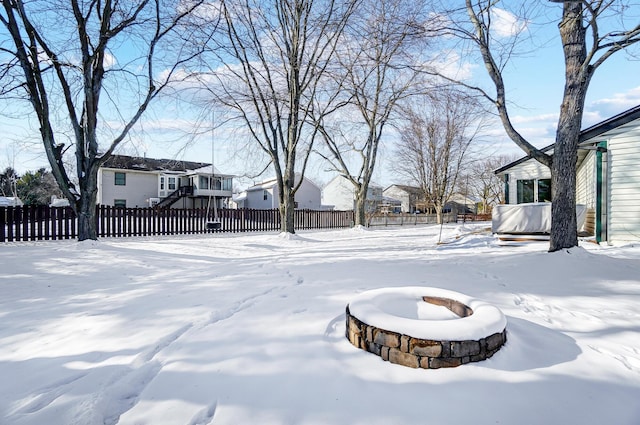 yard layered in snow with an outdoor fire pit