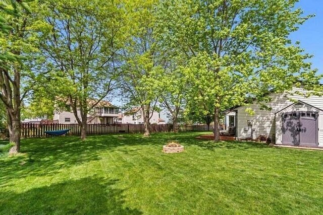 view of yard with a fire pit and a storage shed