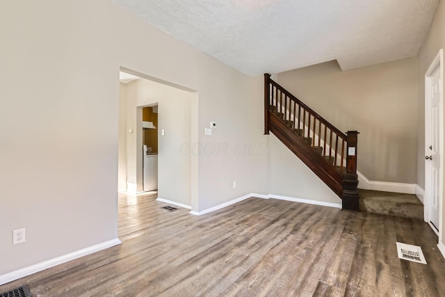 interior space with washer / clothes dryer, hardwood / wood-style floors, and a textured ceiling