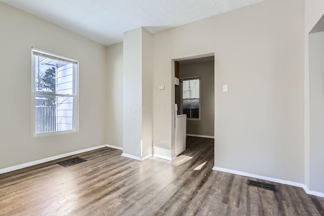 unfurnished room with dark wood-type flooring