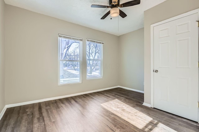 spare room featuring ceiling fan and dark hardwood / wood-style flooring