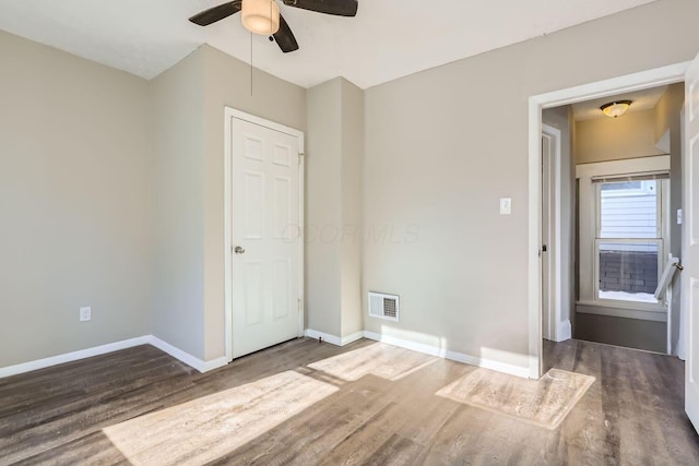 unfurnished room featuring dark wood-type flooring and ceiling fan