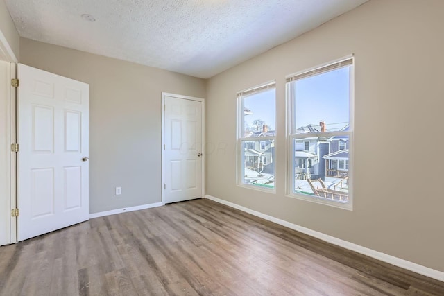 unfurnished bedroom featuring hardwood / wood-style floors and a textured ceiling