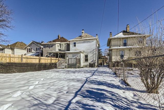 view of snow covered back of property