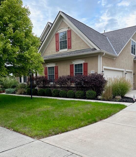 view of front of house with a garage and a front lawn