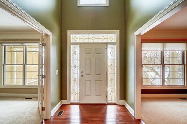 carpeted foyer entrance with crown molding