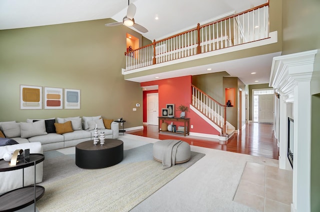 living room with light hardwood / wood-style flooring, high vaulted ceiling, and ceiling fan