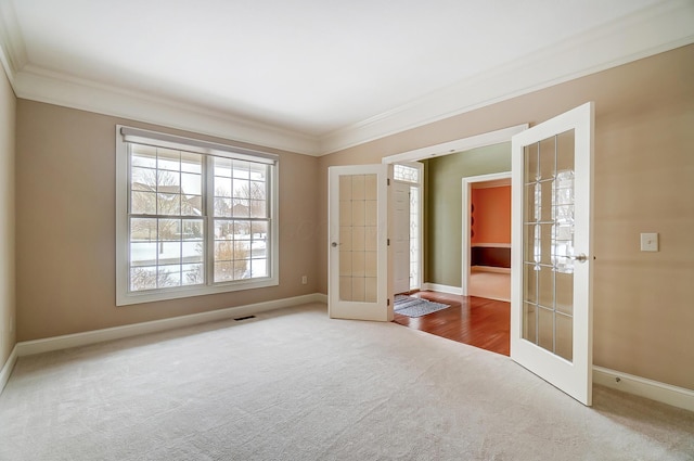 carpeted empty room with ornamental molding and french doors