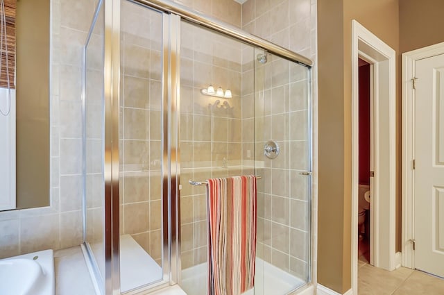 bathroom with tile patterned flooring and a shower with shower door