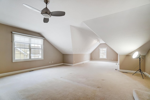 bonus room with ceiling fan, light colored carpet, and vaulted ceiling