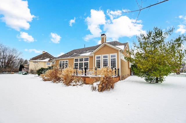 view of snow covered back of property