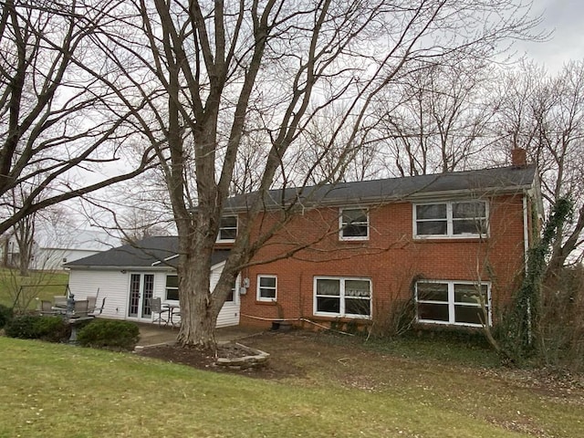 back of house with a lawn and a patio area