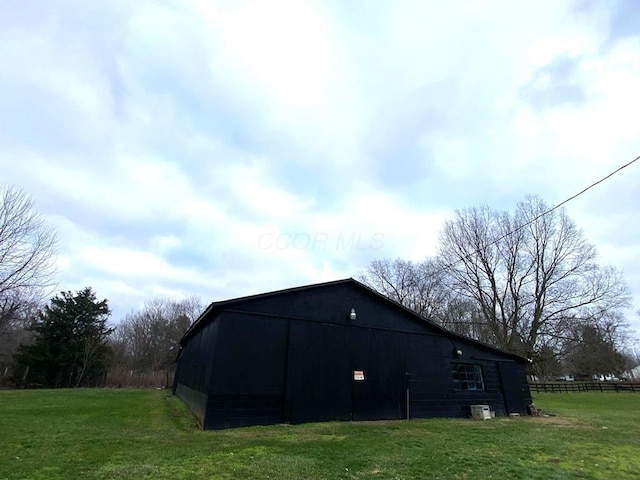 view of home's exterior featuring a lawn and an outdoor structure