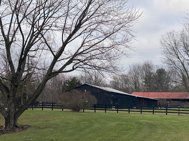 view of property's community with a lawn and fence