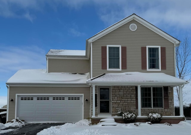 view of property with covered porch and a garage